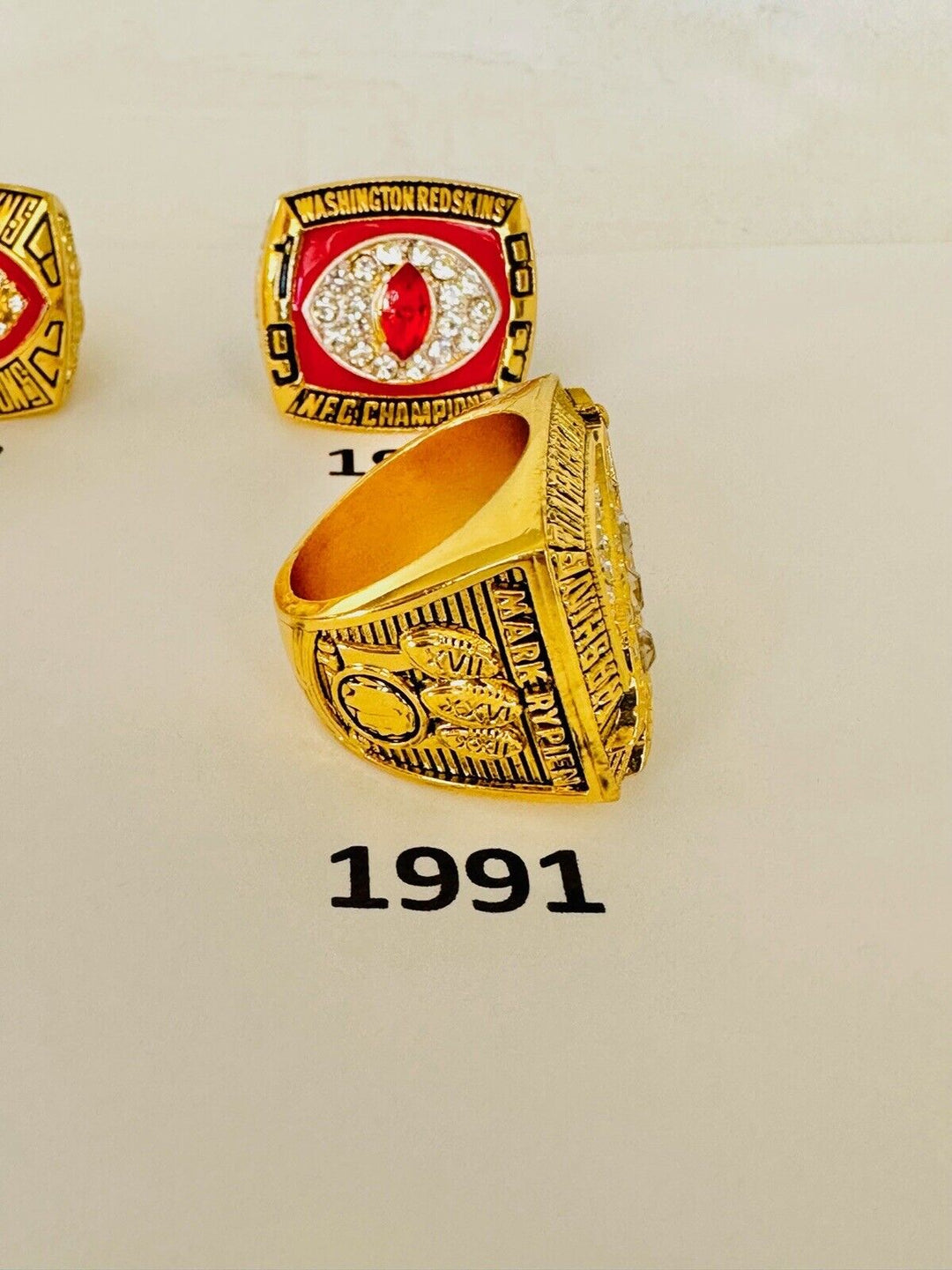Washington Commanders championship ring in gold with team logo, engraved details, and decorative gemstones.